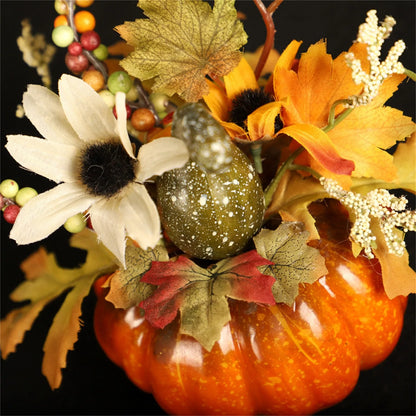 Decorative arrangement with pumpkins, flowers, and leaves on a black background