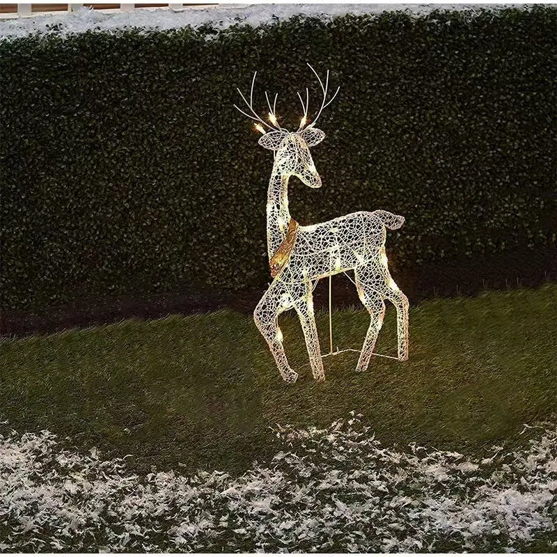 Decorative LED deer figure on a grassy area with a hedge background
