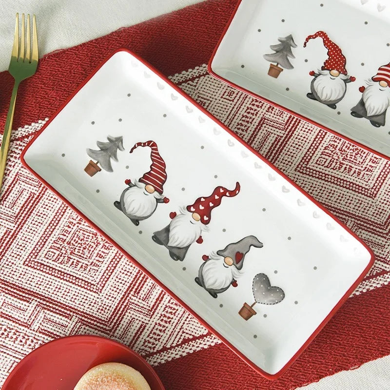 Decorative plate with Christmas-themed gnomes on a red and white patterned tablecloth.