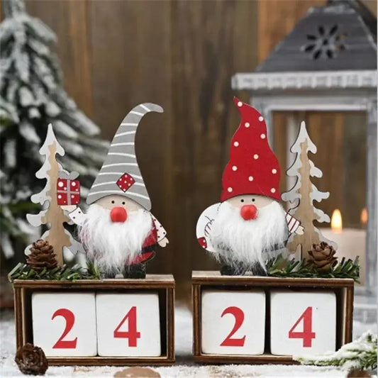Two festive gnomes with red hats on wooden blocks displaying '24' in a snowy outdoor setting.