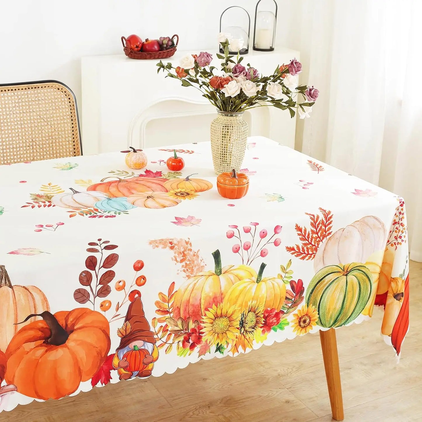Tablecloth with autumn-themed design featuring pumpkins, leaves, and flowers on a table.