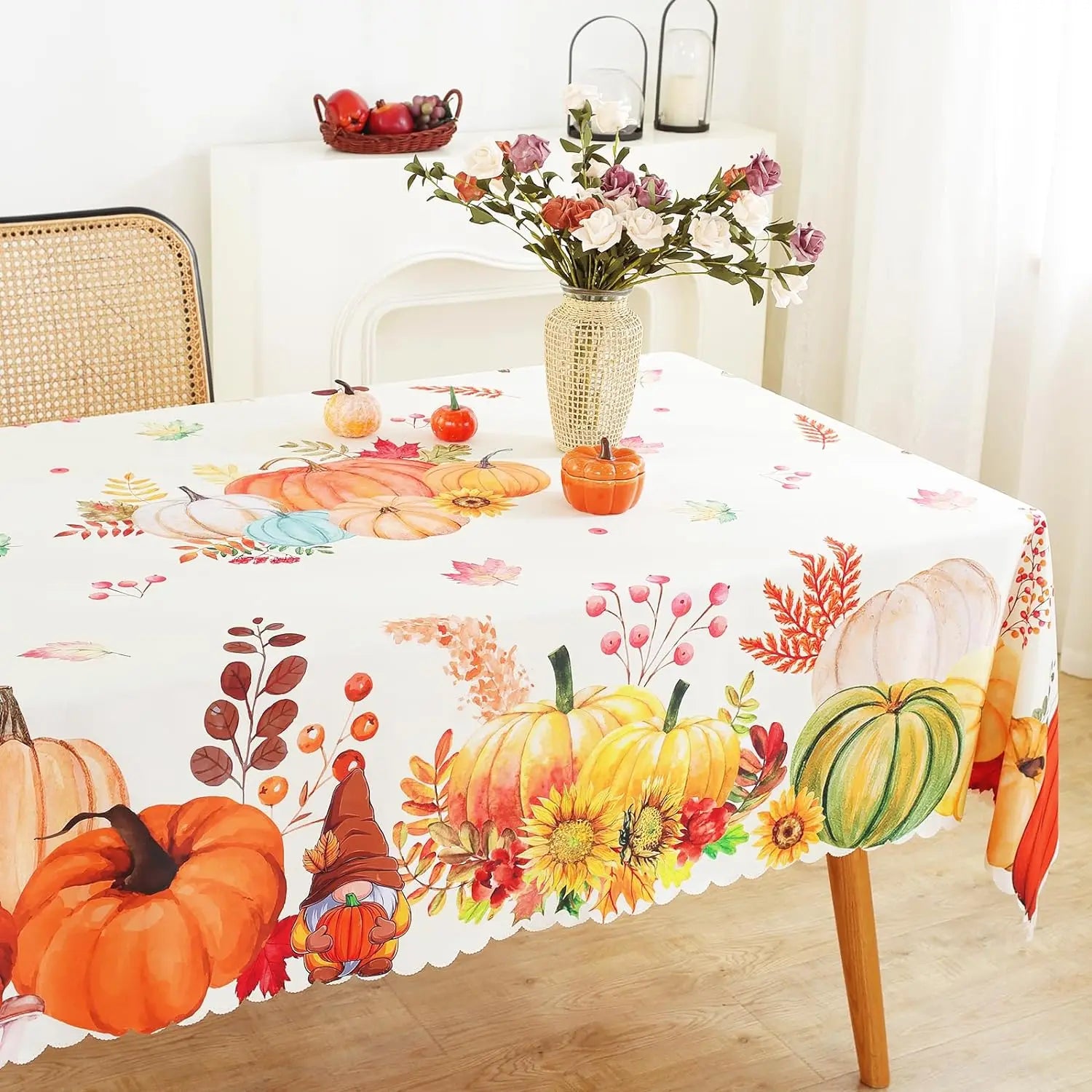 Tablecloth with autumn-themed design featuring pumpkins, leaves, and flowers on a table.