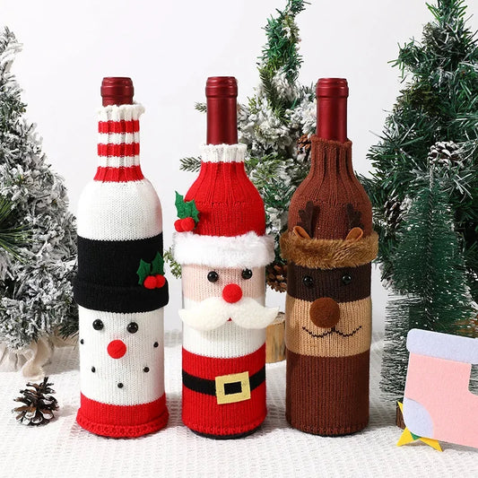Three wine bottles wrapped in festive knitted covers with Christmas-themed designs against a white background.