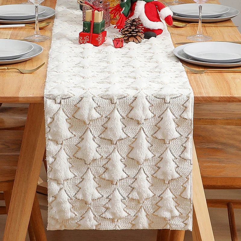 Christmas-themed table setting with a decorative table runner featuring tree patterns on a wooden table.