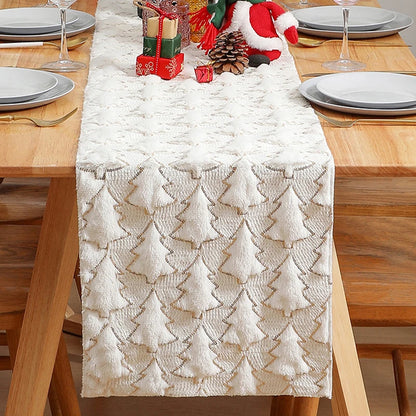 Christmas-themed table setting with a decorative table runner featuring tree patterns on a wooden table.