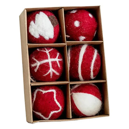 Set of red and white felted balls in a cardboard box on a white background