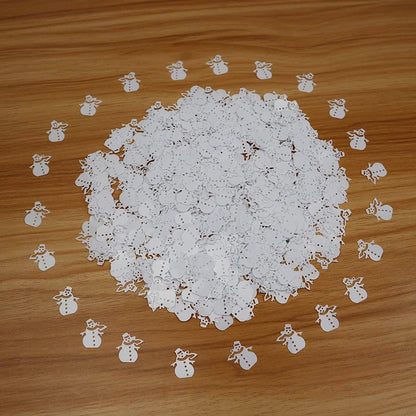 White confetti with cut-out snowman shapes on a wooden surface