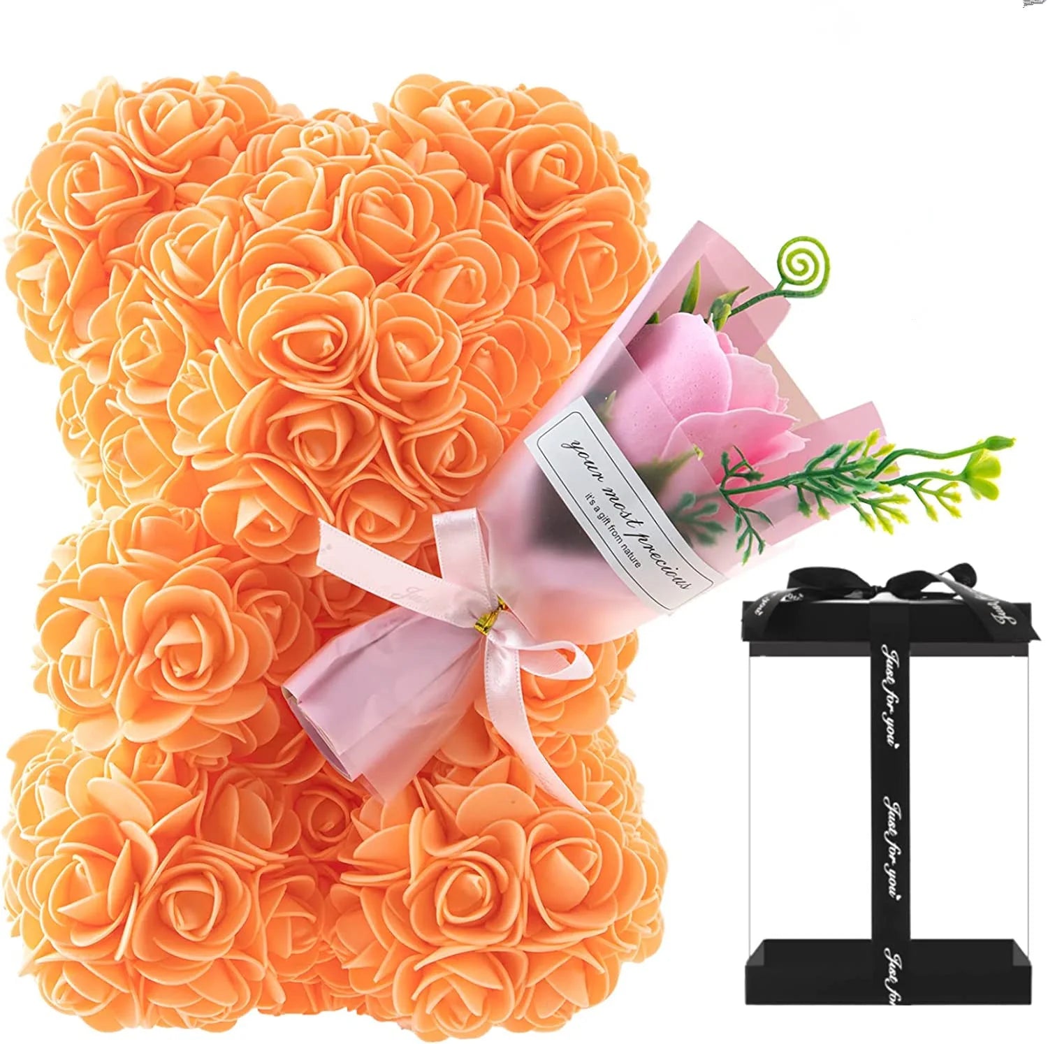 Orange rose-shaped gift with a pink bow and a small bouquet of flowers in the background.