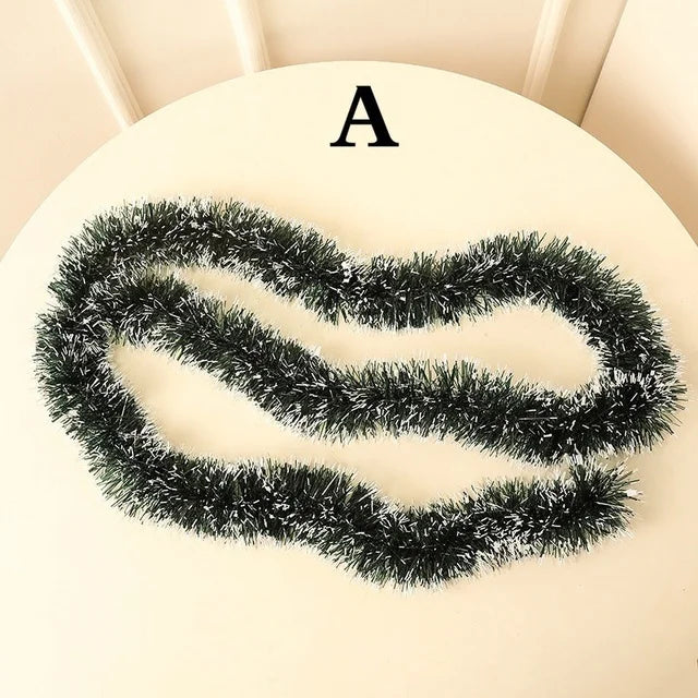 Black tinsel garland on a beige surface with letter 'A' above it