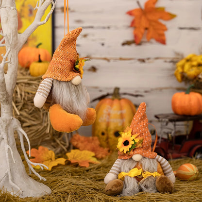 Two autumn-themed gnomes with pumpkins and leaves in a decorative setting.