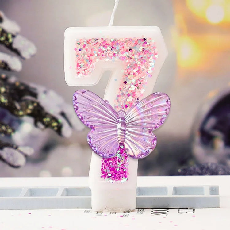 Decorative candle with a butterfly and glittery number on a blurred background