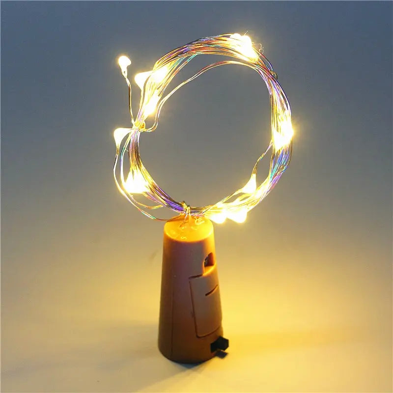 Cork-shaped light with string lights on a dark background