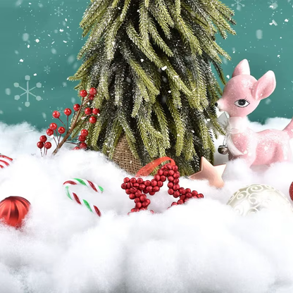 Christmas scene with a decorated tree, ornaments, and a pink deer figurine on snow.