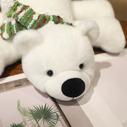 White teddy polar bear with a green and red scarf on a surface