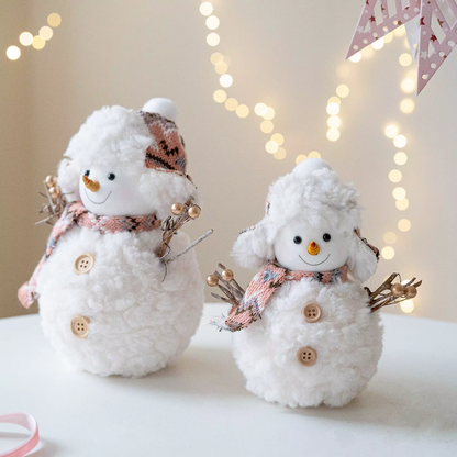 Two decorative snowmen with scarves and buttons on a blurred background with lights